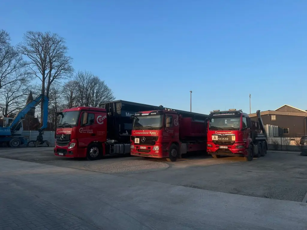 Drei rote LKW vom Schrotthandel Kass auf dem Betriebshof in Brakel mit Containeraufbauten für Schrottabholung und Containerdienst