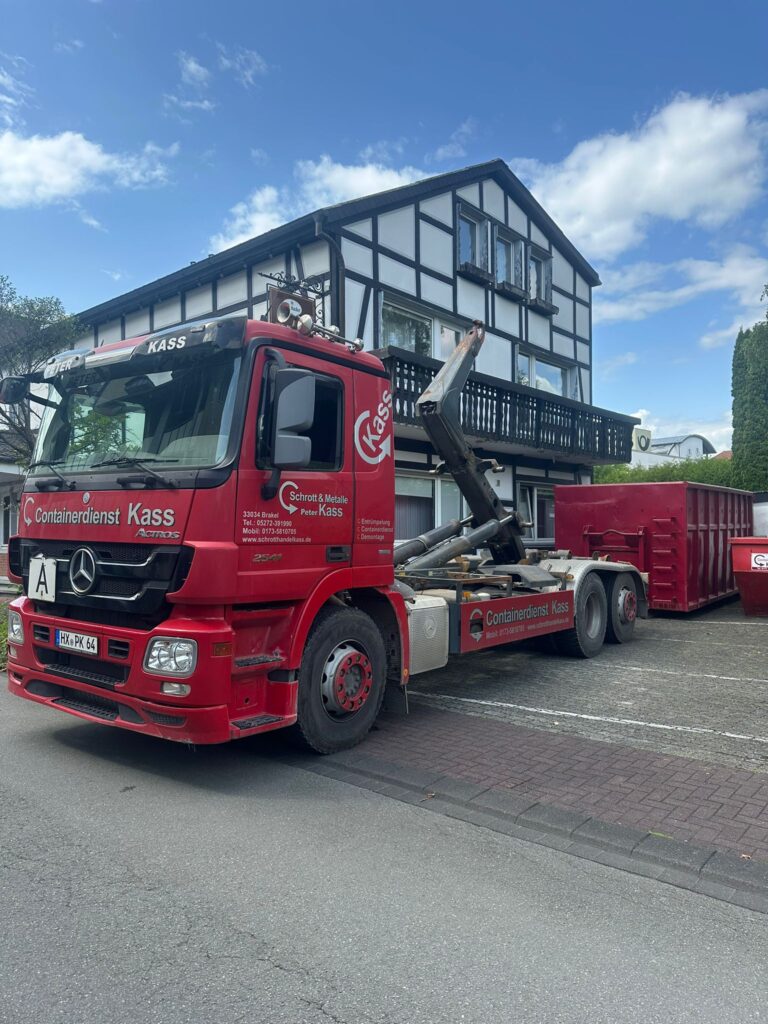 Containerdienst LKW von Schrotthandel Kass in Brakel stellt Container vor einem Wohnhaus zur Entsorgung bereit