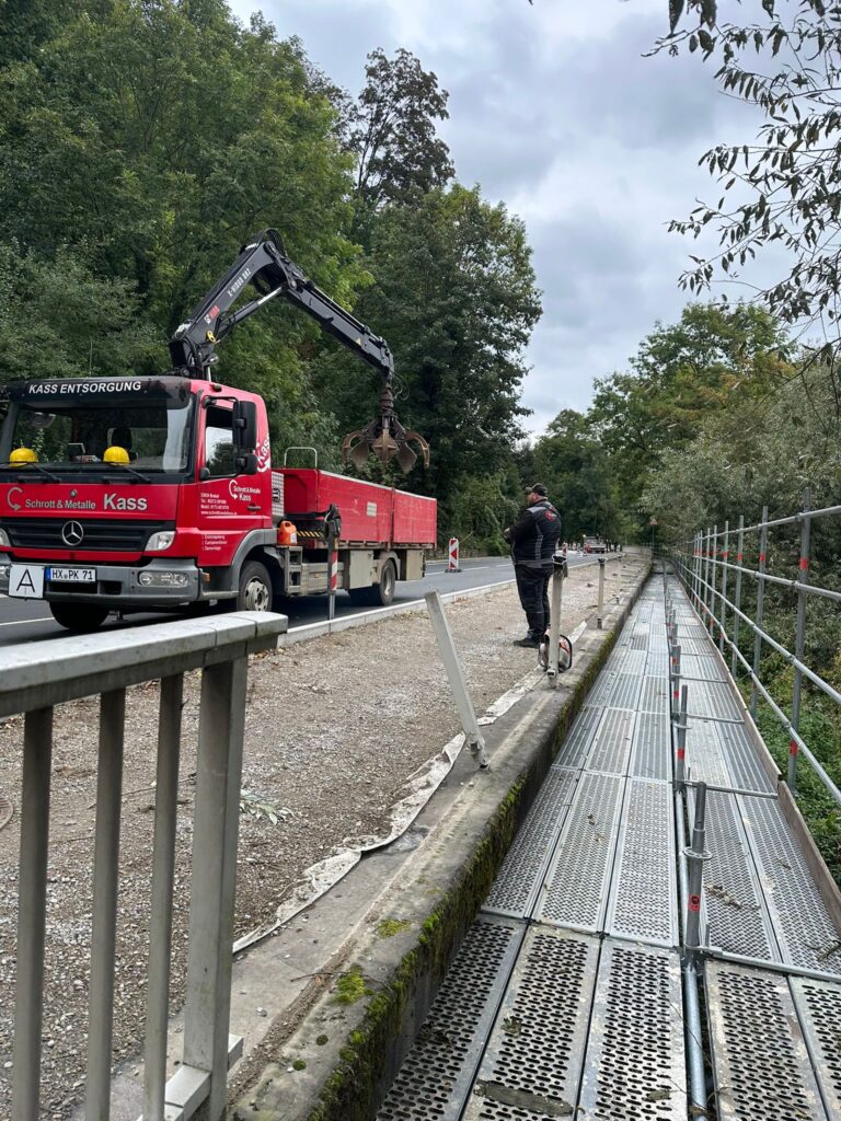 LKW mit Greifarm vom Schrotthandel Kass in Brakel bei Schrottarbeiten entlang einer Straße im Einsatz