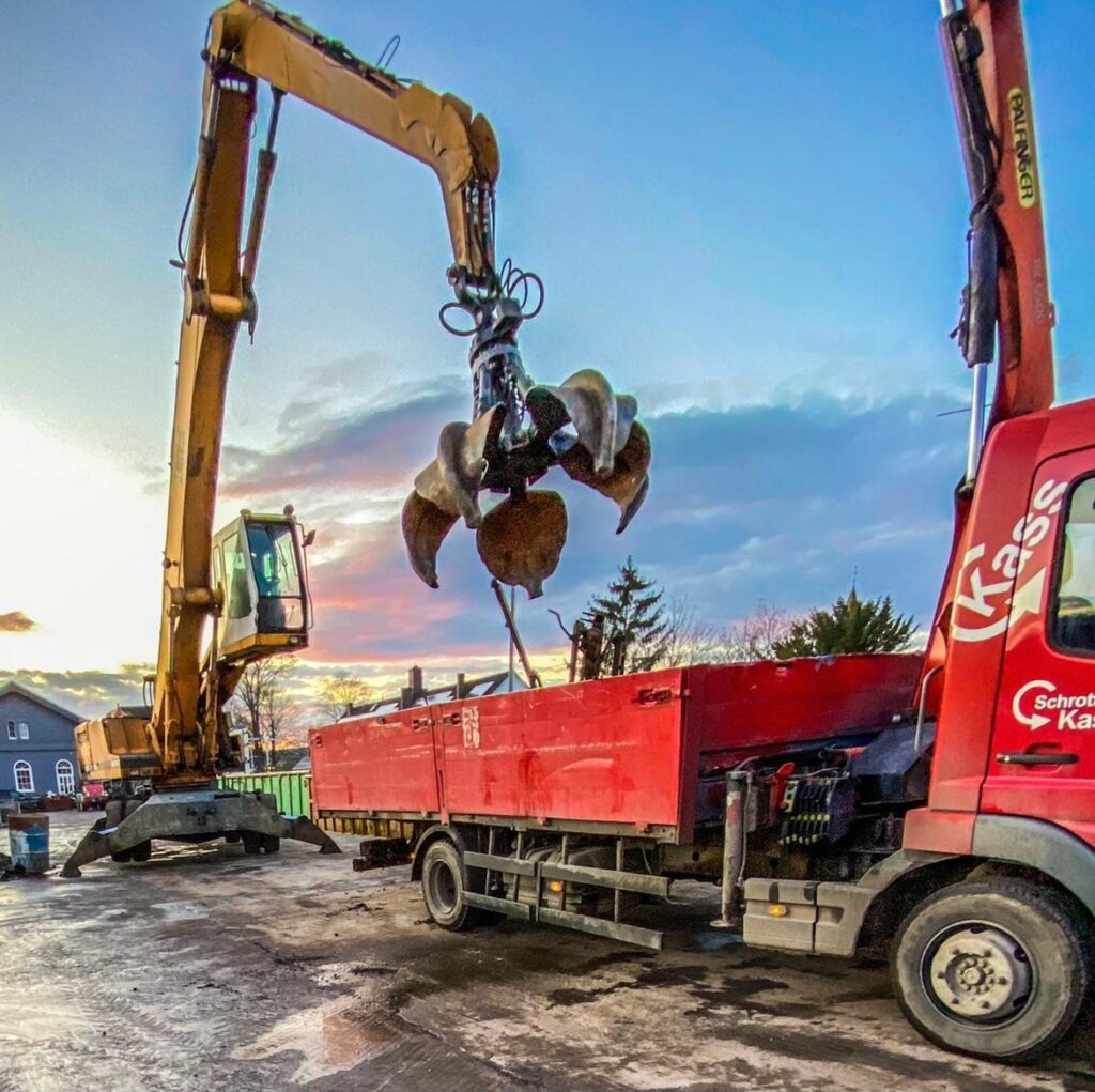 Bagger mit Greifer lädt Metallschrott in einen LKW vom Schrotthandel Kass in Brakel auf dem Betriebshof